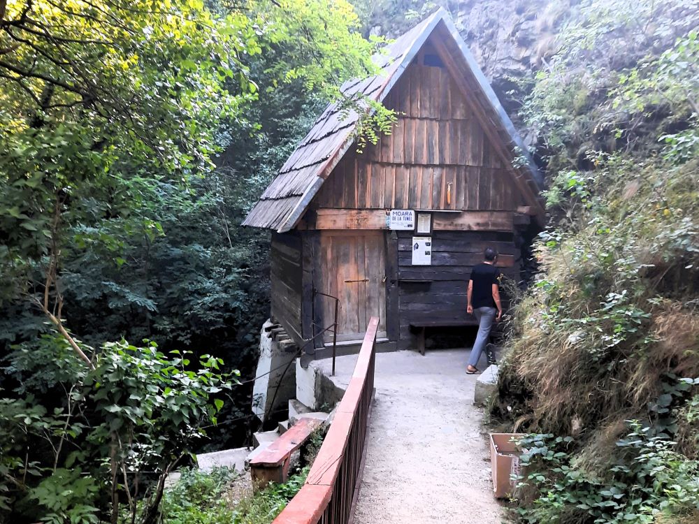 Holzwassermühle in Rudăria, Banat, Rumänien – Besucher vor traditionellem Mühlenhaus im Wald