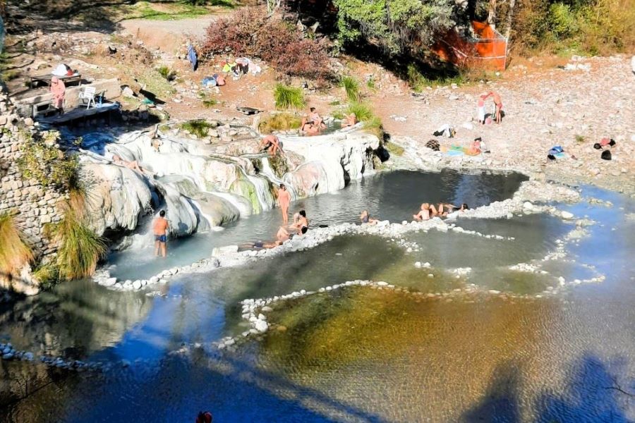 Heiße Schwefelquelle mit Natursteinbecken in Bagni di Petriolo inmitten der toskanischen Landschaft