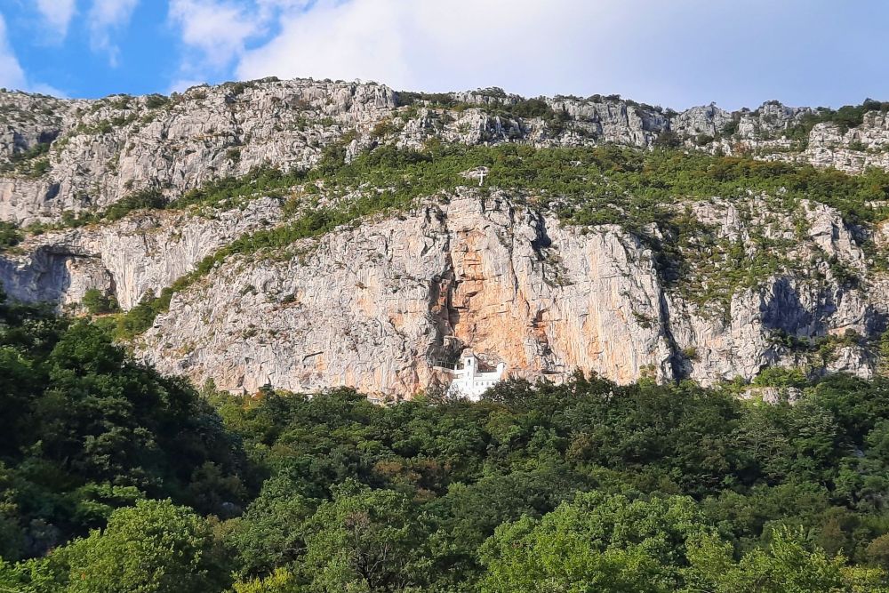 Montenegro. Blick von Gegenüber auf die steile Felswand, in der das Kloster Ostrog gebaut ist