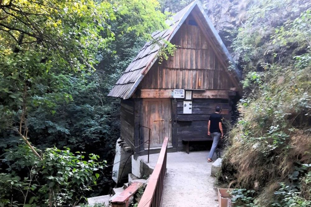 Holzwassermühle in Rudăria, Banat, Rumänien – Besucher vor traditionellem Mühlenhaus im Wald