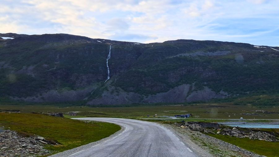 Straße entlang Porsangerfjord mit Wasserfall auf dem Weg zum Nordkapp