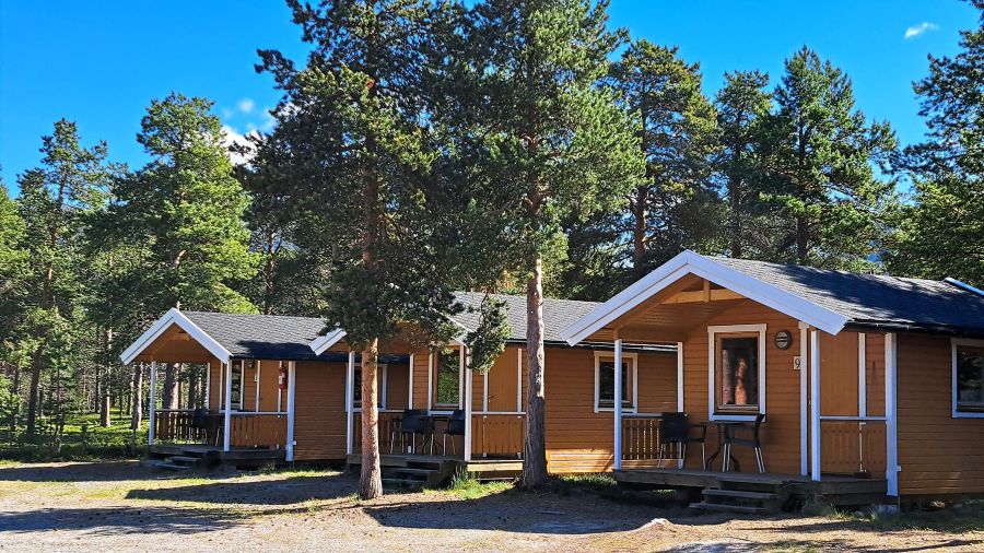 Gelbe Holzhütten zwischen Kiefern auf dem Campingplatz Solvang
