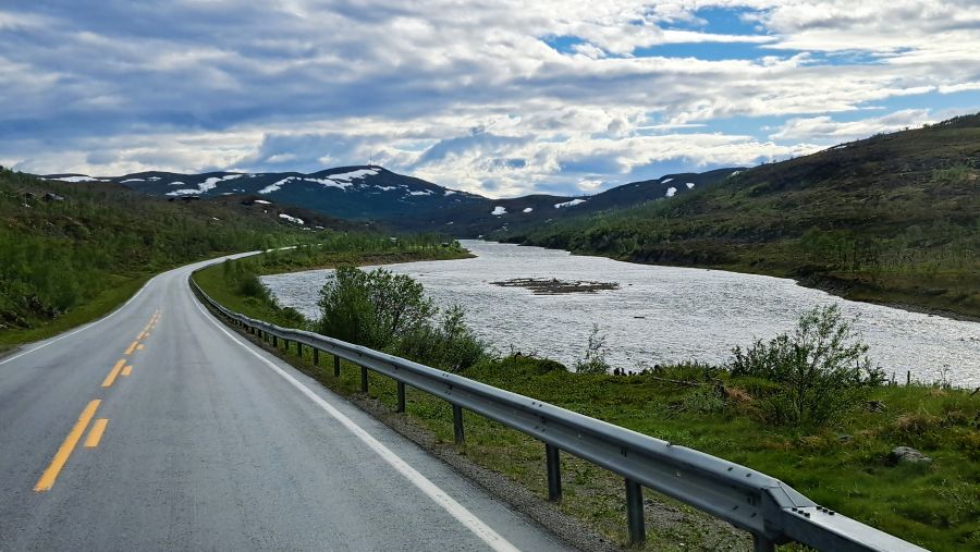 Straße durch die karge Landschaft der Finnmark entlang eines Flusses