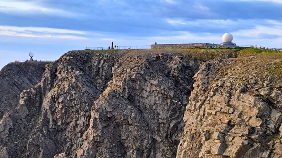 Steilküste am Nordkapp in Norwegen mit Blick auf Globus und Besucherzentrum