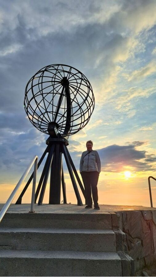 Claudia am Globus des Nordkapps während der Mitternachtssonne