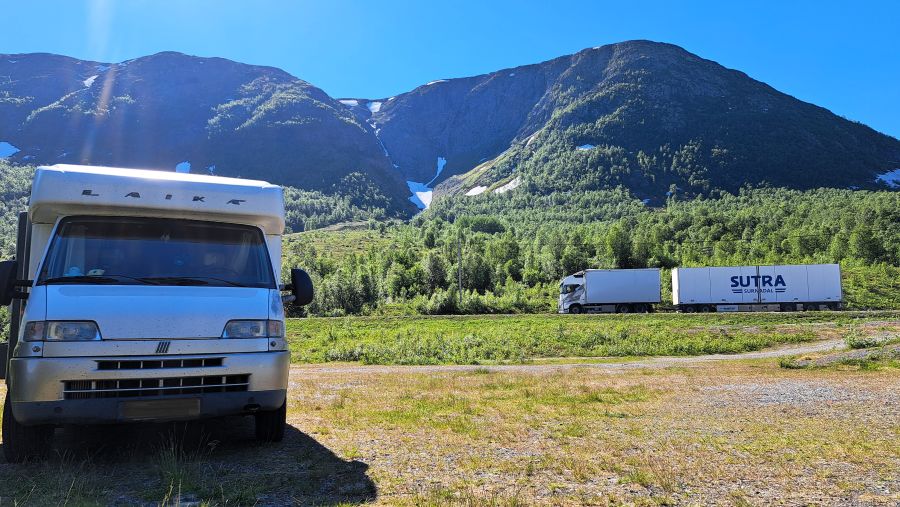 Wohnmobil an der E6 in Nordnorwegen mit vorbeifahrendem LKW