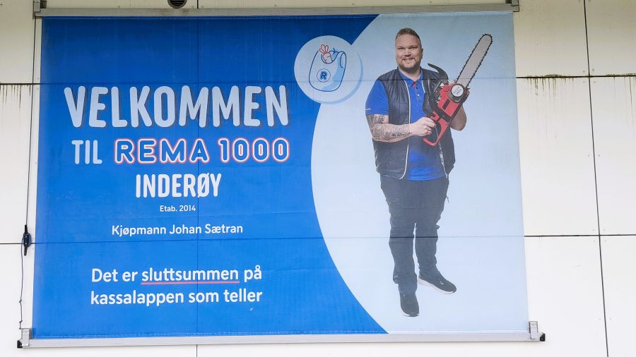 Werbeplakat eines REMA 1000 in Inderøy mit einem Mann und einer Kettensäge