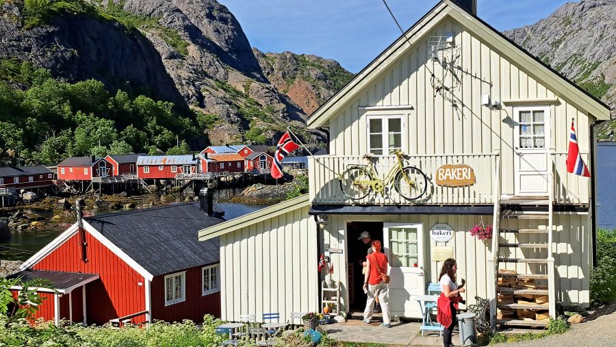 Historische Bäckerei in Nusfjord mit roten Holzhäusern und Felsen im Hintergrund