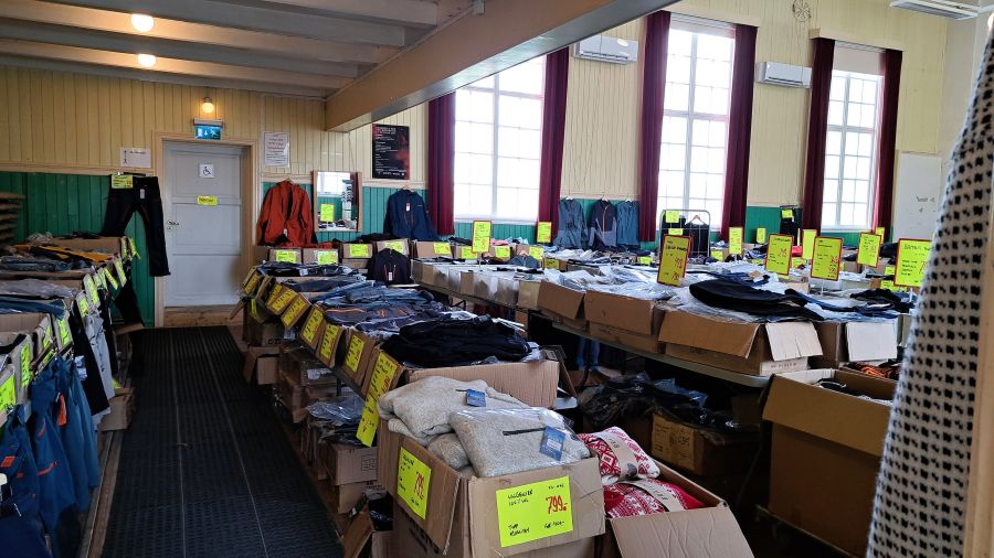 Outlet-Laden in Røros mit Kleidung in Kisten auf langen Tischen