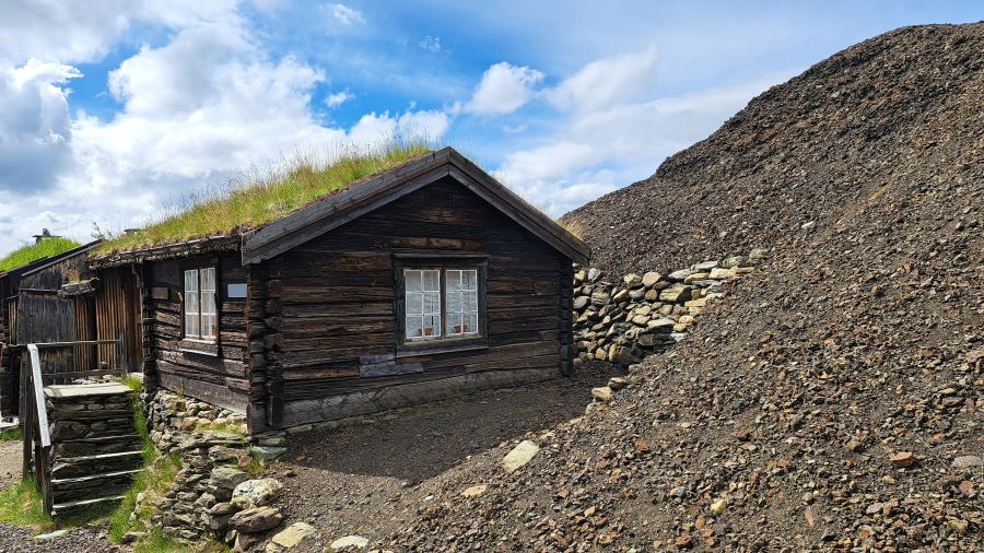 Alte Holzhäuser unmittelbar an den Schlackehalden von Røros