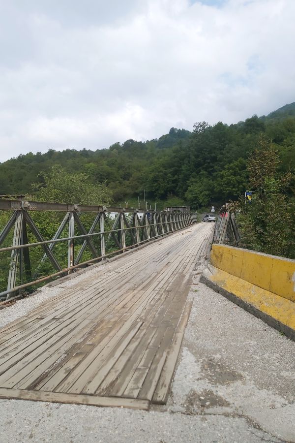 Schmale Stahlbrücke mit Holzfahrbahn über die Tara