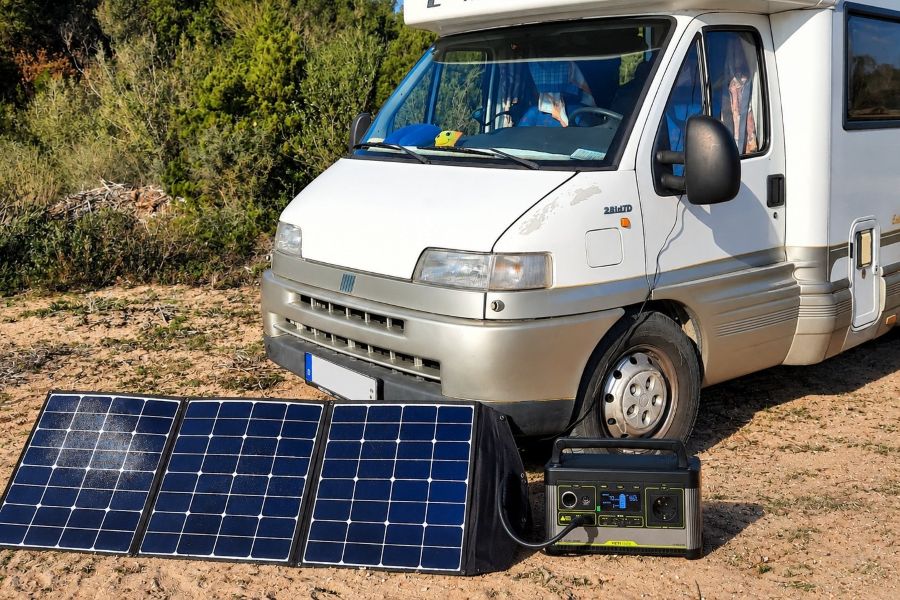 Solarpanel und Powerstation vor einem freistehenden Wohnmobil