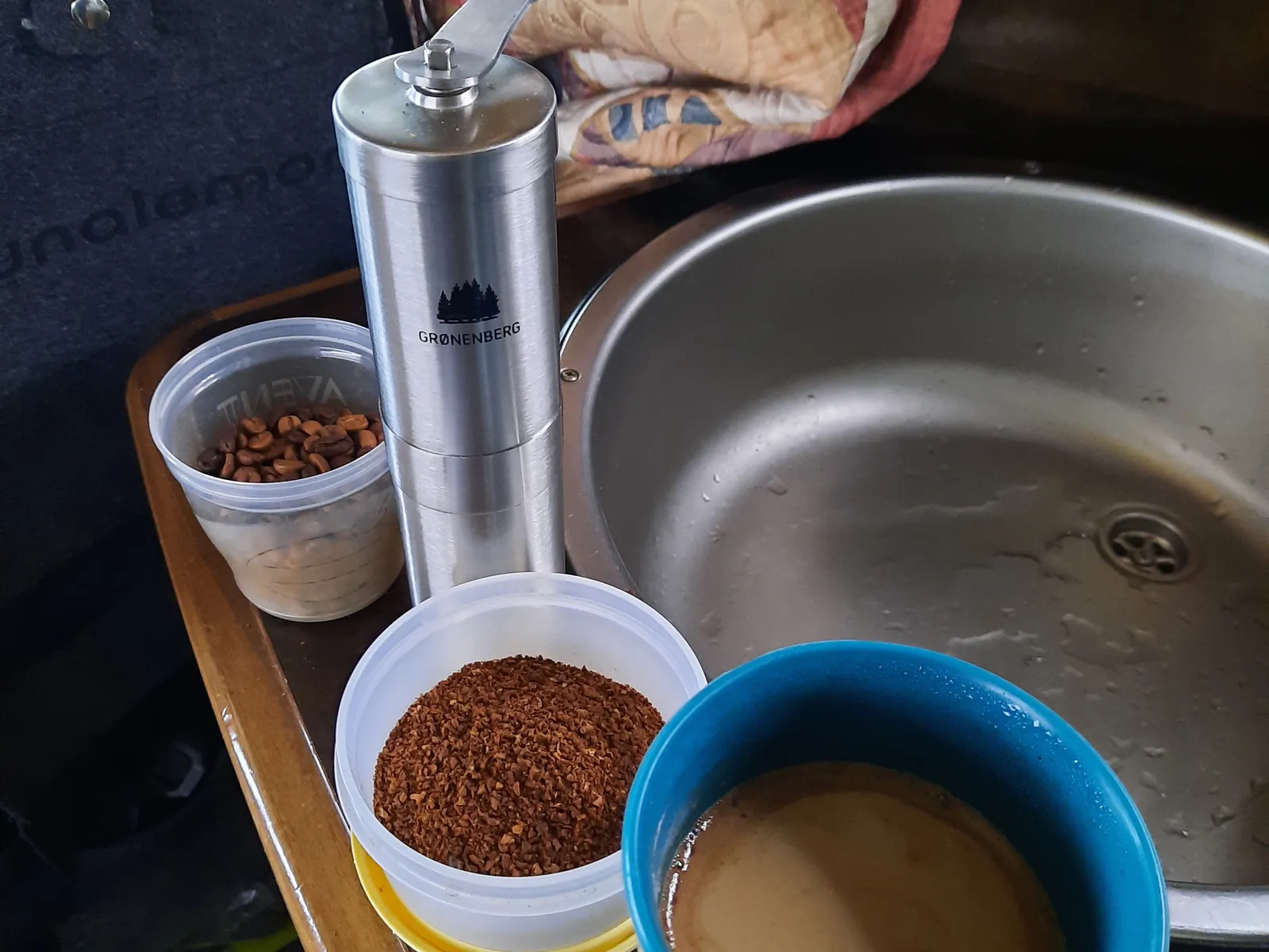 kaffeemuehle-faltbecher-camping Manuelle Kaffeemühle mit frisch gemahlenem Kaffee und faltbarem Becher im Wohnmobil